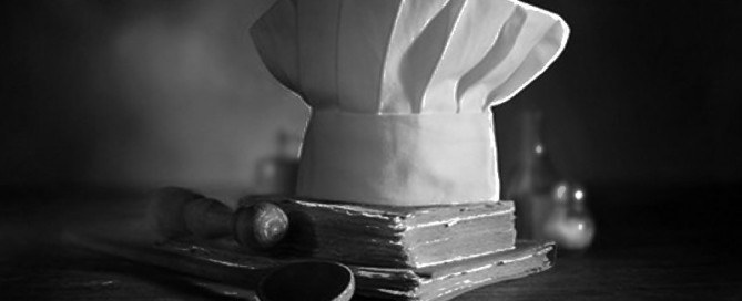 Un cappello da cuoco sopra un libro di cucina